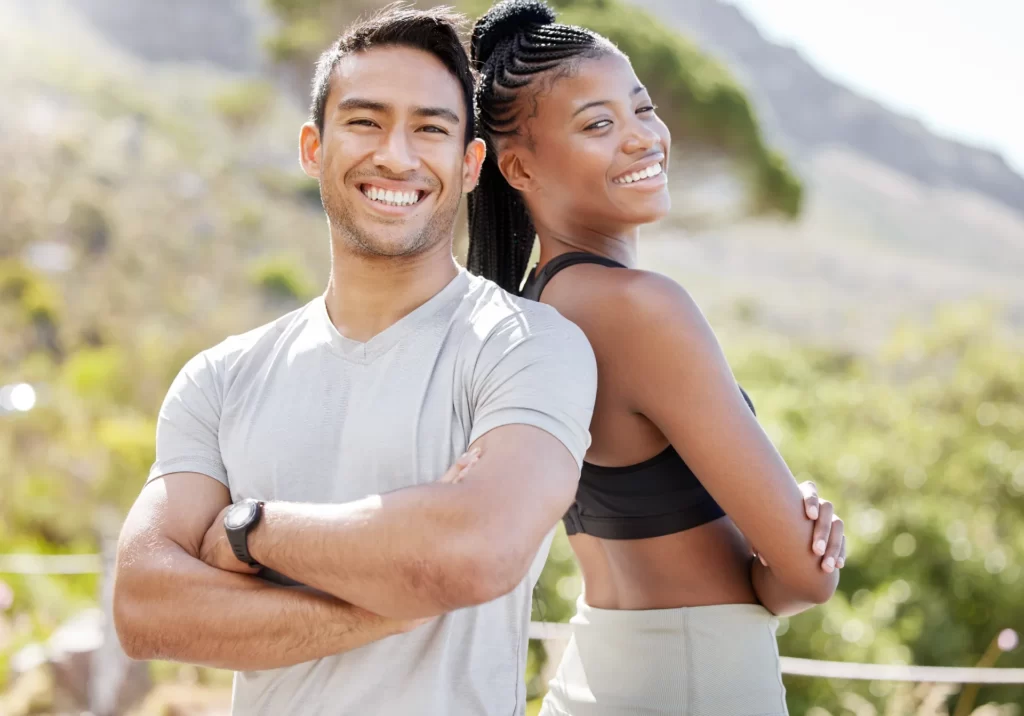 smiling man and woman standing back to back utc